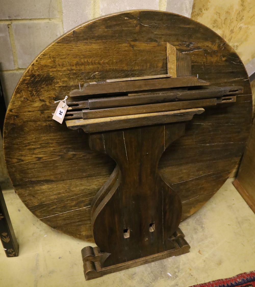 An oak circular table raised on lyre supports, diameter 110cm, height 73cm